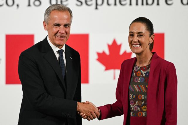 Canada's Prime Minister Mark Carney (L) and Mexico's President Claudia Sheinbaum (R) shake hands after a joint press conference at the National Palace in Mexico City on September 18, 2025. Mexico's President Claudia Sheinbaum and Canada's Prime Minister Mark Carney met in Mexico City as Trump pushes to renegotiate the USMCA North American trade pact in place since 2020. It replaced the NAFTA accord signed in the 1990s. (Photo by Yuri CORTEZ / AFP)
