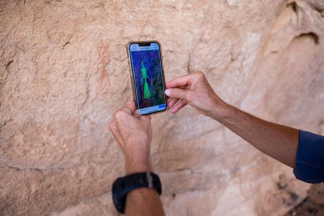 An archeologist uses a mobile phone application that helps to better detect the pigments in cave paintings at the Garoa Hallagana rock art site, in Ennedi Ouest province, Chad, on July 10, 2025. A five-day scientific mission, conducted at the end of July, thirty kilometers from Fada, brought together Chadian archaeologists and geologists from the universities of N'Djamena and Abeche.
The objective: to lay "the first milestone" in the chronological markers of the ancient occupation of the Ennedi region, the researcher asserts.
The Ennedi Natural and Cultural Reserve (RNCE), created in 2018 in this Chadian province, at the crossroads with Libya and Sudan, is home to a rich archaeological heritage.
Across a sanctuary spanning more than 50,000 square kilometers, tens of thousands of rock engravings and paintings adorn the rock faces.
Following the inscription of the RNCE on the World Heritage List in 2016, the Chadian government entrusted its co-management to the South African NGO African Parks for fifteen years. (Photo by Joris Bolomey / AFP)