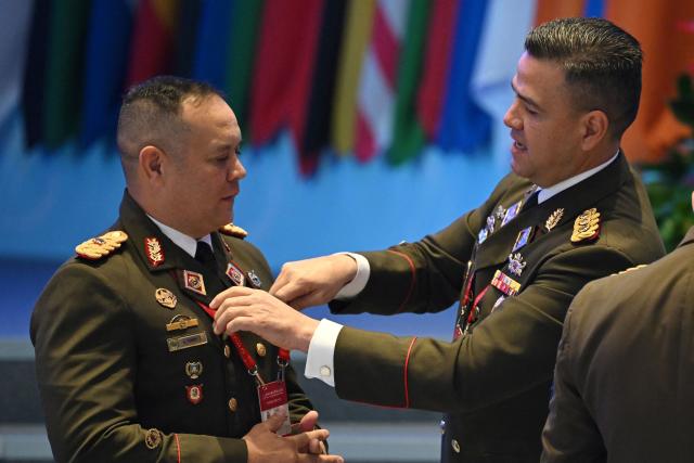 Venezuelan military delegates adjust their uniforms before a plenary session of the Xiangshan Forum in Beijing on September 19, 2025. (Photo by GREG BAKER / AFP)