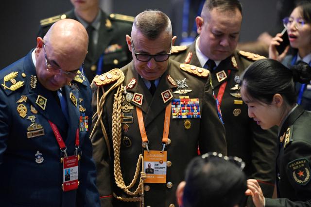 Venezuelan military delegates chat before a plenary session of the Xiangshan Forum in Beijing on September 19, 2025. (Photo by GREG BAKER / AFP)