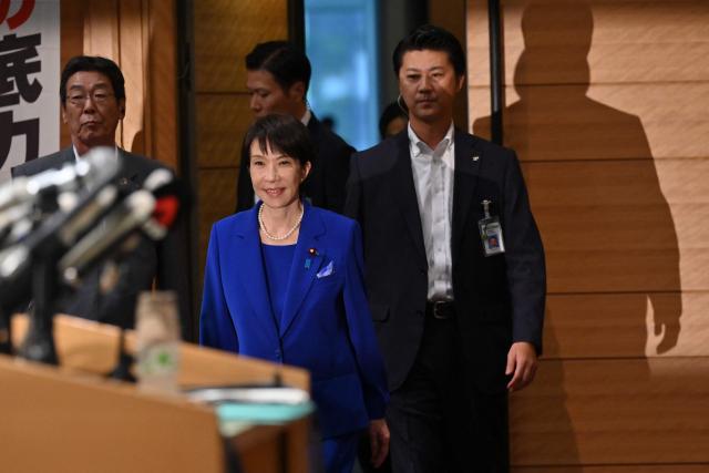 Japanese veteran Liberal Democratic Party (LDP) lawmaker Sanae Takaichi (C) arrives to speak to the media during a press conference in Tokyo on September 19, 2025. Takaichi said on September 18 she will run in the ruling party's leadership election, a campaign that could make her Japan's first woman prime minister. (Photo by Richard A. Brooks / AFP)