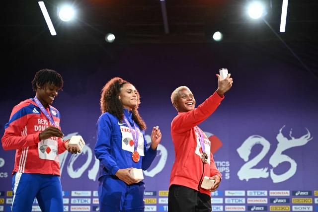 Silver medallist Dominican Republic's athlete Marileidy Paulino (L), Gold medallist US' athlete Sydney Mclaughlin-Levrone and Bronze medallist Bahrain's athlete Salwa Eid Naser celebrate on the podium for the women's 400m during the World Athletics Championships in Tokyo on September 19, 2025. (Photo by Philip FONG / AFP)