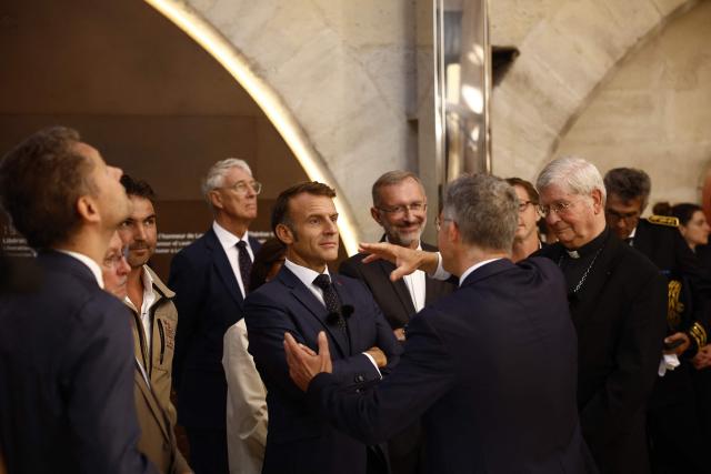 French President Emmanuel Macron (C,L), President of the 'Rebatir Notre-Dame de Paris' public establishment Philippe Jost (front) and Archbishop of Paris, Laurent Ulrich (R) visit the new tour route of the Cathedral towers of the Gothic structure destroyed following the April 2019 fire, as part of the 42nd edition of the European Heritage Days in Paris, on September 6, 2025. The April 15, 2019 fire destroyed the roof and steeple of the 850-year-old Gothic cathedral. The tower visit circuit completes the reopening of the cathedral to the public, that occurred on December 7, 2024, following five years of work involving hundreds of artisans costing nearly 700 million euros. (Photo by Yoan VALAT / POOL / AFP)