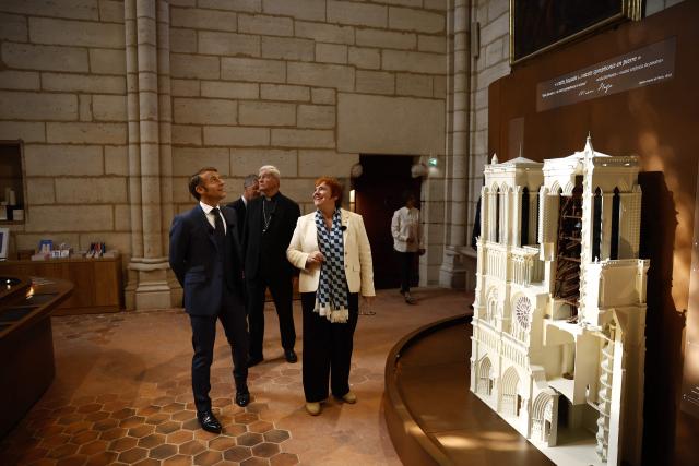 French President Emmanuel Macron (L), Archbishop of Paris, Laurent Ulrich (C) and Marie Lavandier (R) President of the Centre for National Monuments visit the new tour route of the Cathedral towers of the Gothic structure destroyed following the April 2019 fire, as part of the 42nd edition of the European Heritage Days in Paris, on September 6, 2025. The April 15, 2019 fire destroyed the roof and steeple of the 850-year-old Gothic cathedral. The tower visit circuit completes the reopening of the cathedral to the public, that occurred on December 7, 2024, following five years of work involving hundreds of artisans costing nearly 700 million euros. (Photo by Yoan VALAT / POOL / AFP)