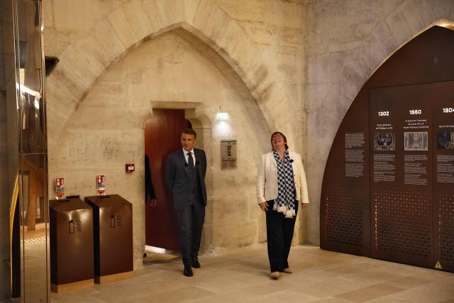 French President Emmanuel Macron (L) and Marie Lavandier (R) President of the Centre for National Monuments visit the new tour route of the Cathedral towers of the Gothic structure destroyed following the April 2019 fire, as part of the 42nd edition of the European Heritage Days in Paris, on September 6, 2025. The April 15, 2019 fire destroyed the roof and steeple of the 850-year-old Gothic cathedral. The tower visit circuit completes the reopening of the cathedral to the public, that occurred on December 7, 2024, following five years of work involving hundreds of artisans costing nearly 700 million euros. (Photo by Yoan VALAT / POOL / AFP)