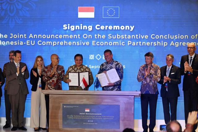 Indonesia's Coordinating Minister for Economic Affairs Airlangga Hartarto (center-L) and EU Commissioner for Trade and Economic Security, Interinstitutional relations and Transparency Maros Sefcovic (center-R) hold their signed joint announcements on the Substantial Conclusion of the Indonesia-EU Comprehensive Economic Partnership Agreement in Nusa Dua, on Indonesia resort island of Bali on September 23, 2025. The Indonesia-European Union Comprehensive Economic Partnership Agreement, signed by EU Trade Commissioner Maros Sefcovic and Indonesian Minister of Economic Affairs Airlangga Hartarto, will bring resource-rich Indonesia and the 27-member European Union into closer economic ties. (Photo by Sonny TUMBELAKA / AFP)