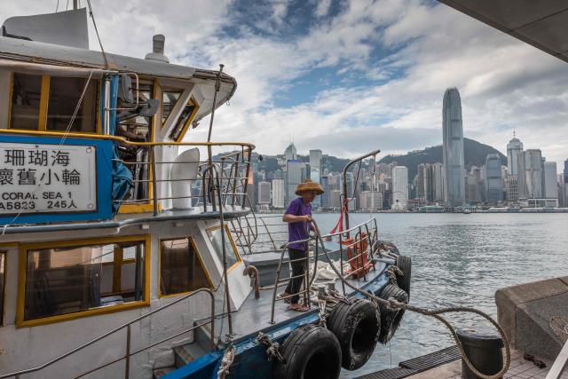A ferry worker releases a rope at Victoria Harbour as Super Typhoon Ragasa moved towards Hong Kong on September 23, 2025. Hong Kong shut schools and cancelled flights on September 23 as Super Typhoon Ragasa was set to slam into the financial centre with a force that officials warned would be among the most destructive in the city's recent history. (Photo by Dale DE LA REY / AFP)