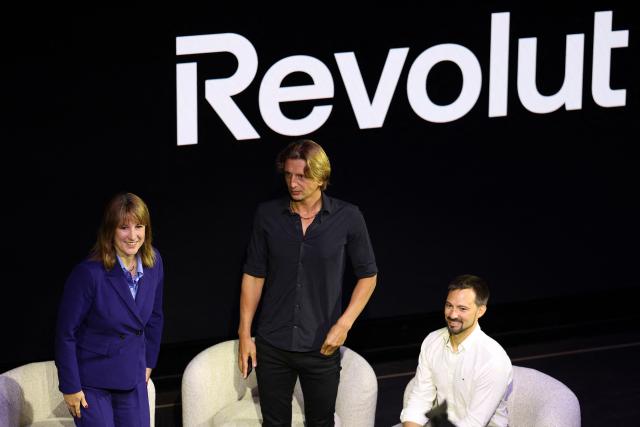 Britain's Chancellor of the Exchequer Rachel Reeves (L), Revolut bank's CEO Nikolay Storonsky (2R) and Revolut bank's Chief Technology Officer, Vlad Yatsenko, take part in an event to open Revolut's new global headquarters in the Canary wharf financial district of east London, on September 23, 2025. (Photo by Adrian Dennis / AFP)