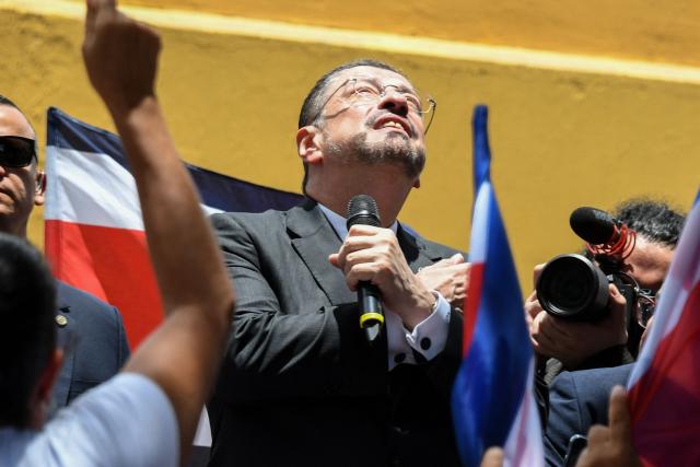 (FILES) Costa Rica's President Rodrigo Chaves greets supporters after appearing before the Special Commission for the Lifting of Immunity of Members of the Legislative Assembly in San Jose on August 22, 2025. Chaves survived a vote in Congress on stripping him of his immunity so that he could be tried for corruption. on September 22, 2025. The motion to remove his immunity garnered 34 votes in favor to 21 against, falling four votes short of the 38 votes needed for the motion to pass in the 57-seat unicameral legislature. (Photo by Ezequiel BECERRA / AFP)