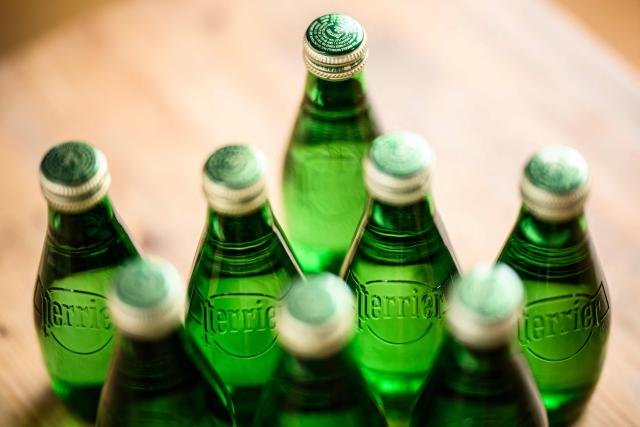 (FILES) This picture taken shows Perrier sparkling water bottles in Nantes, western France, on May 19, 2025. On September 24, 2025 morning, the French consumer association, UFC-Que Choisir, will ask the Nanterre court to temporarily withdraw Perrier bottles, a Nestle Waters brand, considering their marketing as "natural mineral water" to be misleading (Photo by Loic VENANCE / AFP)