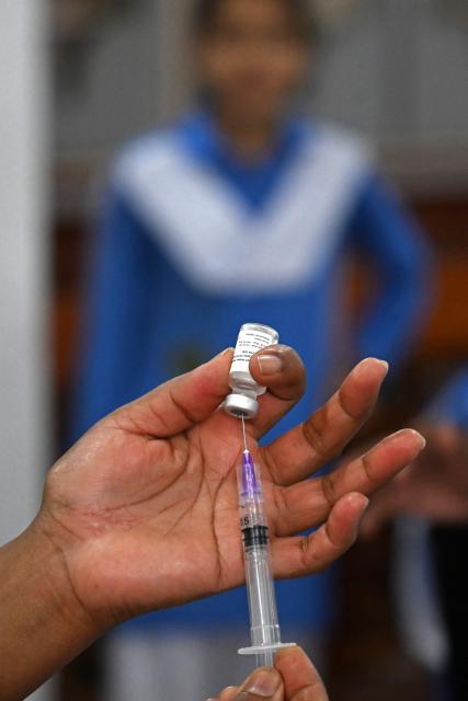 A health worker prepares to inject human papillomavirus (HPV) vaccine to a school student in Islamabad on September 24, 2025, during a vaccination drive held to protect adolescent girls from cervical cancer. (Photo by Farooq NAEEM / AFP)