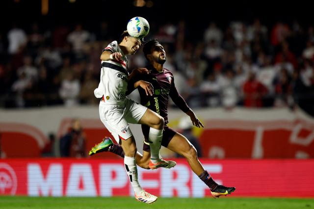 Sao Paulo's Paraguayan midfielder #21 Damian Bobadilla (L) and Liga de Quito's Colombian forward #16 Jeison Medina (R) fight for the ball during the Copa Libertadores quarterfinal second leg football match between Brazil's Sao Paulo and Ecuador's Liga de Quito, at the Morumbi stadium in Sao Paulo, Brazil on September 25, 2025. (Photo by Miguel SCHINCARIOL / AFP)