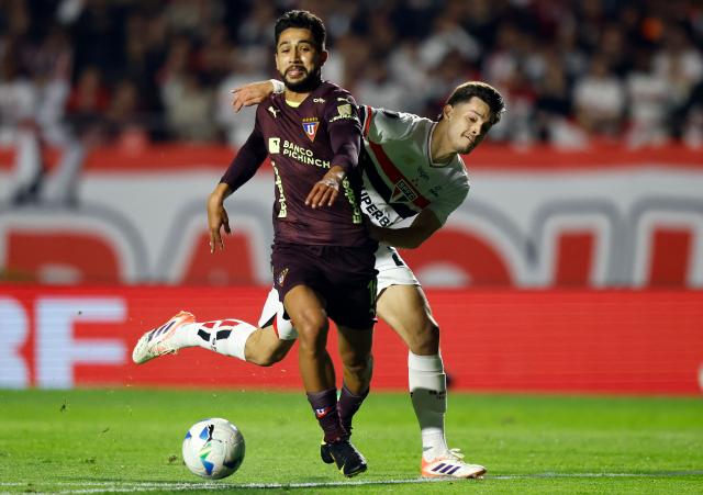 Liga de Quito's Colombian forward #16 Jeison Medina (L) and Sao Paulo's Paraguayan midfielder #21 Damian Bobadilla (R) fight for the ball during the Copa Libertadores quarterfinal second leg football match between Brazil's Sao Paulo and Ecuador's Liga de Quito, at the Morumbi stadium in Sao Paulo, Brazil on September 25, 2025. (Photo by Miguel SCHINCARIOL / AFP)