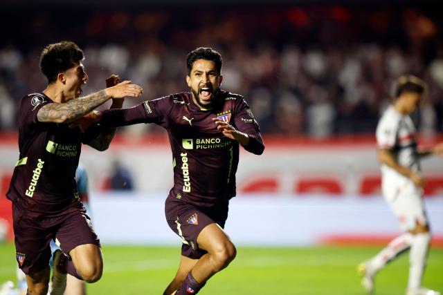 Liga de Quito's Colombian forward #16 Jeison Medina (R) celebrates with teammate Bolivian midfielder #15 Gabriel Villamil (L) after scoring his team's first goal during the Copa Libertadores quarterfinal second leg football match between Brazil's Sao Paulo and Ecuador's Liga de Quito, at the Morumbi stadium in Sao Paulo, Brazil on September 25, 2025. (Photo by Miguel SCHINCARIOL / AFP)