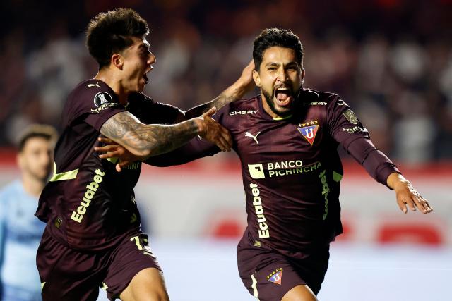 Liga de Quito's Colombian forward #16 Jeison Medina (R) celebrates with teammate Bolivian midfielder #15 Gabriel Villamil (L) after scoring his team's first goal during the Copa Libertadores quarterfinal second leg football match between Brazil's Sao Paulo and Ecuador's Liga de Quito, at the Morumbi stadium in Sao Paulo, Brazil on September 25, 2025. (Photo by Miguel SCHINCARIOL / AFP)