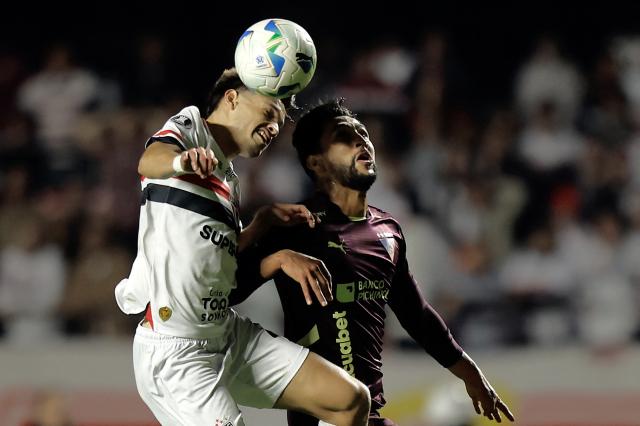 Sao Paulo's Paraguayan midfielder #21 Damian Bobadilla (L) and Liga de Quito's Colombian forward #16 Jeison Medina (R) fight for the ball during the Copa Libertadores quarterfinal second leg football match between Brazil's Sao Paulo and Ecuador's Liga de Quito, at the Morumbi stadium in Sao Paulo, Brazil on September 25, 2025. (Photo by Miguel SCHINCARIOL / AFP)