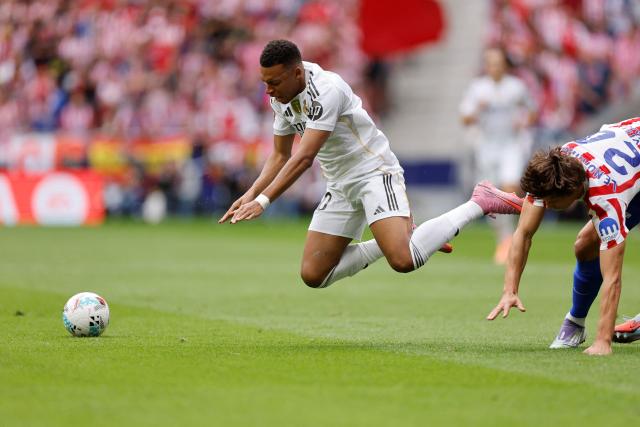 Real Madrid's French forward #10 Kylian Mbappe falls as he fights for the ball with Atletico Madrid's Spanish defender #24 Robin Le Normand
during the Spanish league football match between Club Atletico de Madrid and Real Madrid CF at the Metropolitano stadium in Madrid on September 27, 2025. (Photo by Oscar DEL POZO / AFP)