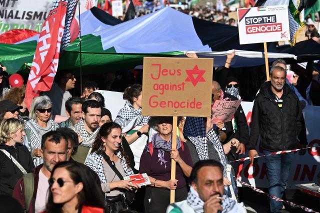 Participants display a placard with the lettering 'Jews Against Genocide' as people march during a demonstration under the motto 'Draw the red line with us: Together for Gaza!' in Berlin on September 27, 2025. (Photo by RALF HIRSCHBERGER / AFP)