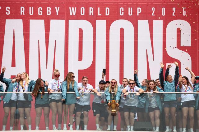 England's captain Zoe Aldcroft holds the trophy as England players celebrate at a Red Roses Champions Party, held at Battersea Power Station in central London on September 28, 2025, after their win in the final of the Women’s Rugby World Cup against Canada the previous day. England coach insisted the Red Roses could "dominate the world for a long time" after their 33-13 win over Canada in the Women's Rugby World Cup final at Twickenham on Saturday. (Photo by HENRY NICHOLLS / AFP)