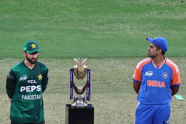 India's captain Suryakumar Yadav (R) and his Pakistani counterpart Salman Agha stand on the field for the toss before the start of the Asia Cup 2025 Twenty20 international cricket final match between India and Pakistan at the Dubai International Stadium in Dubai on September 28, 2025. (Photo by Fadel SENNA / AFP)