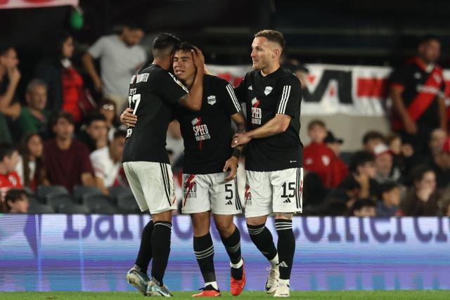 Deportivo Riestra's defender #05 Pedro Ramirez celebrates with teammates defender #27 Jonatan Goitia and defender #15 Nicolas Sansotre after scoring his team's second goal during the Argentine Professional Football League 2025 Clausura Tournament match between River Plate and Deportivo Riestra, at the Mas Monumental Stadium in Buenos Aires, on September 28, 2025. (Photo by ALEJANDRO PAGNI / AFP)