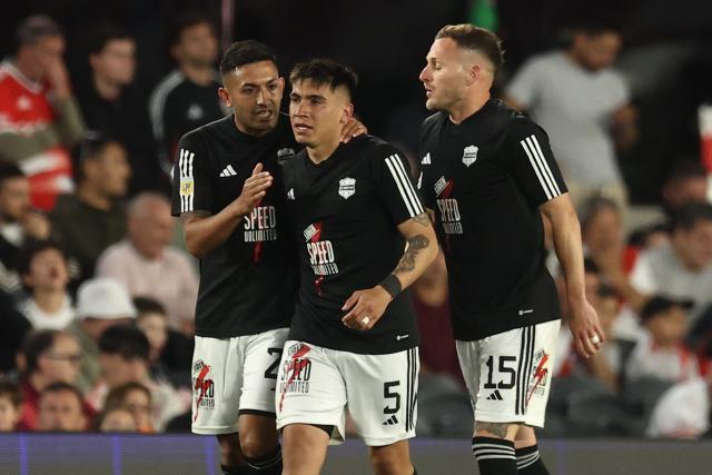 Deportivo Riestra's defender #05 Pedro Ramirez celebrates with teammates defender #27 Jonatan Goitia and defender #15 Nicolas Sansotre after scoring his team's second goal during the Argentine Professional Football League 2025 Clausura Tournament match between River Plate and Deportivo Riestra, at the Mas Monumental Stadium in Buenos Aires, on September 28, 2025. (Photo by ALEJANDRO PAGNI / AFP)