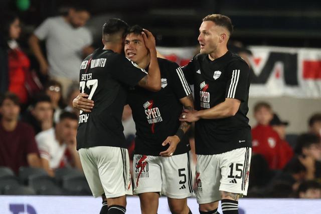 Deportivo Riestra's defender #05 Pedro Ramirez celebrates with teammates defender #27 Jonatan Goitia and defender #15 Nicolas Sansotre after scoring his team's second goal during the Argentine Professional Football League 2025 Clausura Tournament match between River Plate and Deportivo Riestra, at the Mas Monumental Stadium in Buenos Aires, on September 28, 2025. (Photo by ALEJANDRO PAGNI / AFP)