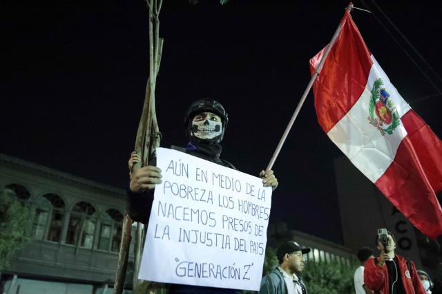 A demonstrator wearing a mask walks towards the congress building during an anti-government demonstration in Lima on September 28, 2025. (Photo by CONNIE FRANCE / AFP)