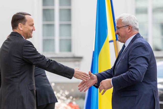Poland's Deputy Prime Minister and Foreign Affairs Minister Radoslaw Sikorski (L) welcomes Ukraine's Foreign Minister Andriy Sybiga (R) as he arrives to join Germany's Foreign Affairs Minister and France's Minister for Europe and Foreign Affairs in a so-called Weimar Triangle formula, in Warsaw, on September 29, 2025. (Photo by Wojtek RADWANSKI / AFP)