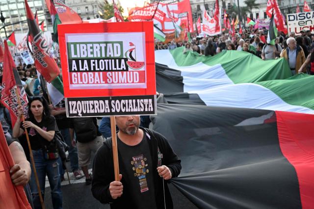 Pro-Palestinian demonstrators wave Palestinian flags and hold banners during a protest against the Israeli army's interception of the Global Sumud Flotilla in Buenos Aires, on October 1, 2025. (Photo by Luis ROBAYO / AFP)