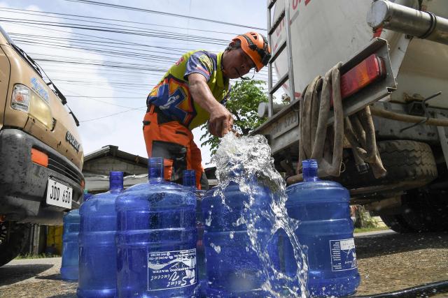 A fireman fills plastic containers with free water for residents in Bogo City, Cebu province on October 2, 2025, in the aftermath of a 6.9-magnitude quake that struck off the coast of the central Philippines late September 30. The death toll from a powerful earthquake in the central Philippines rose to 72 on October 2, rescuers said, as officials turned their efforts to the hundreds injured and thousands left homeless. (Photo by Ted ALJIBE / AFP)