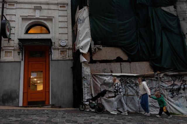Pedestrians walk down the street at the Podil neighbourhood of Kyiv, on October 2, 2025, amid the Russian invasion of Ukraine. (Photo by Tetiana DZHAFAROVA / AFP)