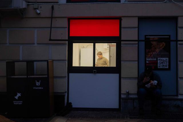 A man looks at a phone in a shop at the Podil neighbourhood of Kyiv on October 2, 2025, amid the Russian invasion of Ukraine. (Photo by Tetiana DZHAFAROVA / AFP)