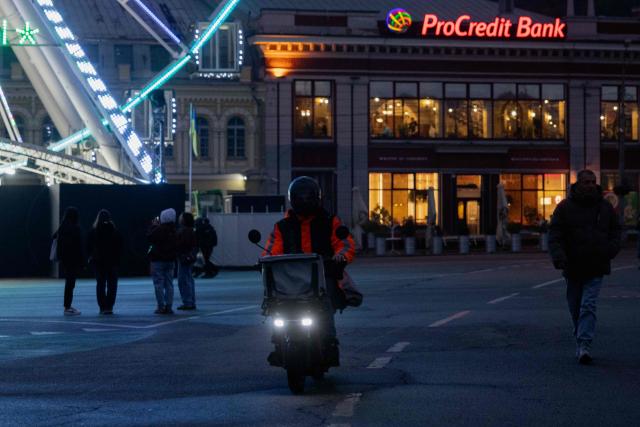 A man rides a motorcycle down the street in the Podil neighbourhood of Kyiv on October 2, 2025, amid the Russian invasion of Ukraine. (Photo by Tetiana DZHAFAROVA / AFP)