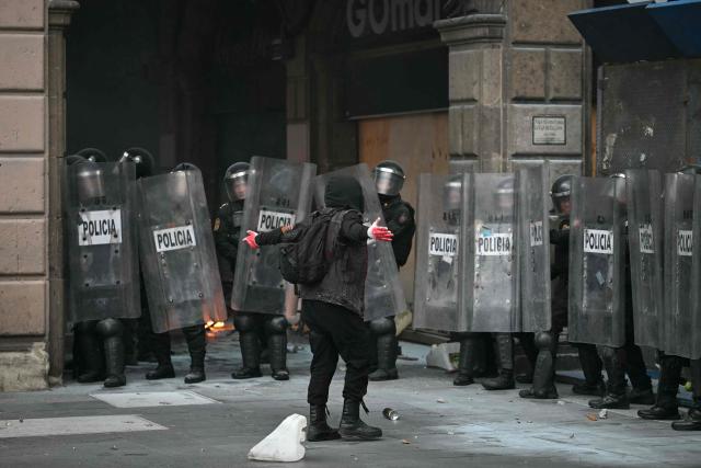 A demonstrator clashes with riot police during a rally commemorating the 57th anniversary of the 1968 Tlatelolco student massacre in Mexico City on October 2, 2025. (Photo by Yuri CORTEZ / AFP)