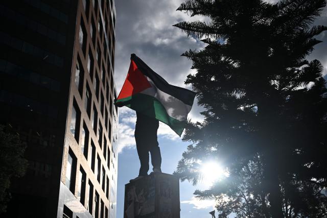 A demonstrator holds a Palestinian flag during a protest in solidarity with Palestinians and to condemn the interception of the Global Sumud Flotilla by the Israeli army in Bogota on October 2, 2025. (Photo by Raul ARBOLEDA / AFP)