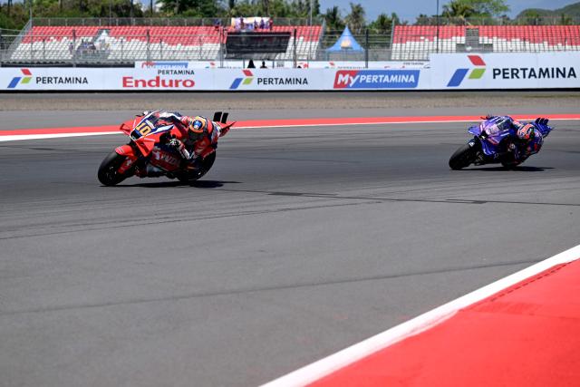 Honda HRC Castrol team's  Italian MotoGP rider Luca Marini (L) and Prima Pramac Yamaha MotoGP team's Australian MotoGP rider Jack Miller ride during the free practice ahead of the MotoGP Indonesian Grand Prix at the Mandalika International Circuit in Mandalika, West Nusa Tenggara on October 3, 2025. (Photo by SONNY TUMBELAKA / AFP)