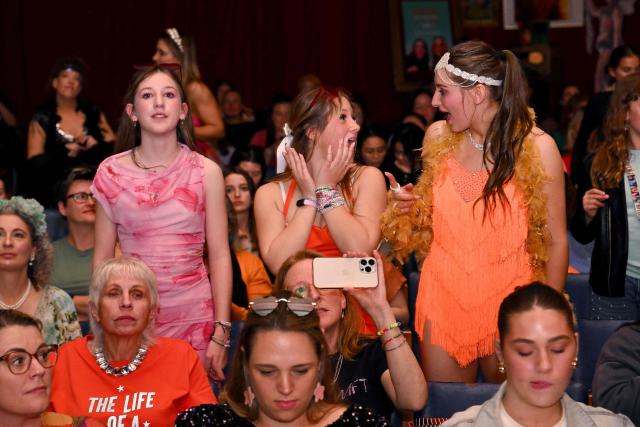 Taylor Swift fans dance during a listening event for Swift's new album 'The Life of a Showgirl' at the Astor Theatre in Melbourne on October 3, 2025. Swift on October 3 dropped her 12th studio album, "The Life of a Showgirl," a collection of bouncy pop songs about love, marriage, success -- and score-settling. For the hotly anticipated album, the 35-year-old artist reunited with Swedish hitmakers Max Martin and Shellback, and their influence is clear in the driving beats and catchy hooks. (Photo by William WEST / AFP)