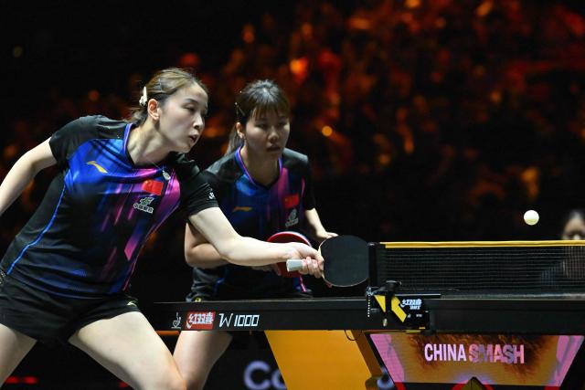 China’s Qian Tianyi (L) and Chen Xingtong (R) play a point against China’s Kuai Man and Wang Manyu during their women’s doubles semi-final match at the China Smash table tennis tournament in Beijing on October 3, 2025. (Photo by ADEK BERRY / AFP)