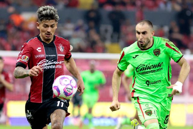 Atlas' Paraguayan forward #11 Diego Gonzalez and Juarez's defender #04 Alejandro Mayorga fight for the ball during the Liga MX Apertura football match between Atlas and Juarez at the Jalisco Stadium in Guadalajara, Jalisco state, Mexico on October 3, 2025. 11 Rojo vs Verde 4 (Photo by Ulises Ruiz / AFP)