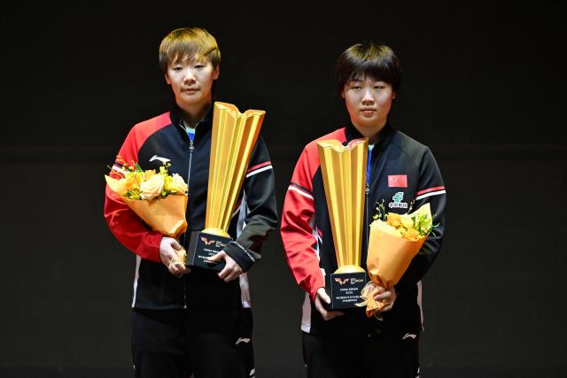 China's Wang Manyu (L) and Kuai Man pose with the trophy after their victory in the women's doubles final against Japan's Hina Hayata and South Korea's Joo Cheon-hui at the China Smash table tennis tournament in Beijing on October 4, 2025. (Photo by WANG Zhao / AFP)