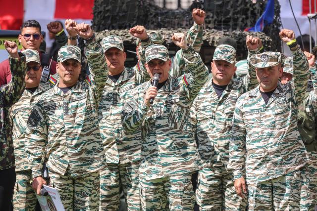 Venezuela's Defense Minister Vladimir Padrino Lopez (C) speaks during a training session of the Bolivarian National Militia in Caracas on October 4, 2025. Venezuelan soldiers carried out communication drills on Saturday in preparation for a possible armed conflict, in response to what they denounce as a “siege” by the US. (Photo by Pedro MATTEY / AFP)