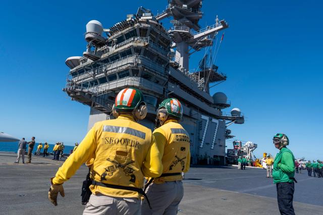 Crew members stand on the flight deck aboard the USS George H.W. Bush aircraft carrier in the Atlantic Ocean off the coast of Norfolk, Virginia on October 4, 2025. (Photo by Alex Brandon / POOL / AFP)