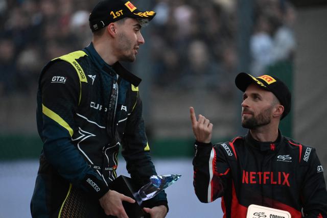 Spanish Youtuber "Karchez" (L) and French YouTuber Lucas Hauchard aka "Squeezie" (R) talk at the end of a sprint race, part of the F4 GP Explorer racing event at the Bugatti circuit in Le Mans, western France, on October 4, 2025. The three-day event brought together 200,000 spectators and some of the biggest names in French rap. (Photo by JEAN-FRANCOIS MONIER / AFP)
