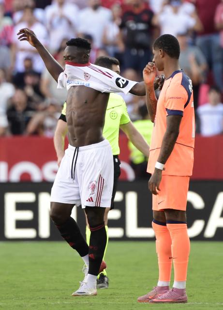 Sevilla's Nigerian forward #09 Akor Jerome Adams (L) celebrates scoring his team's fourth goal next to Barcelona's English forward #14 Marcus Rashford during the Spanish league football match between Sevilla FC and FC Barcelona at Ramon Sanchez Pizjuan Stadium in Seville on October 5, 2025. (Photo by CRISTINA QUICLER / AFP)