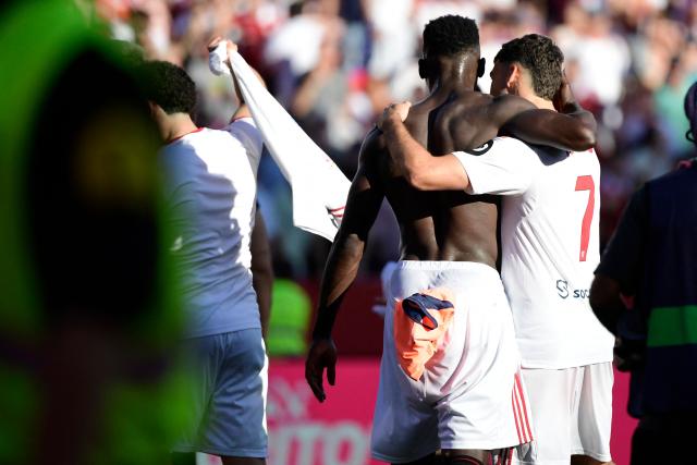 Sevilla's Spanish forward #07 Isaac Romero and Sevilla's Nigerian forward #09 Akor Jerome Adams hug each other at the end of the Spanish league football match between Sevilla FC and FC Barcelona at Ramon Sanchez Pizjuan Stadium in Seville on October 5, 2025. (Photo by CRISTINA QUICLER / AFP)