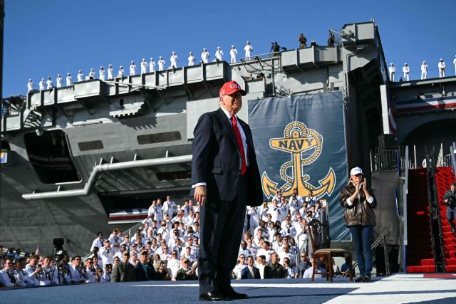 US President Donald Trump and US First Lady Melania Trump walk onstage to deliver remarks during a visit to the USS Harry S. Truman during the US Navy's 250th anniversary celebration, "America's Navy 250: Titans of the Sea - A Salute to the Fleet", at Naval Station Norfolk Pier 14 in Norfolk, Virginia on October 5, 2025. (Photo by SAUL LOEB / AFP)