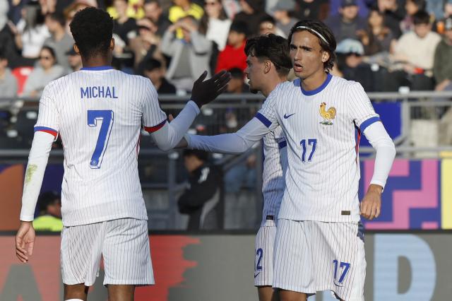 France's midfielder #17 Andrea Le Borgne celebrates with teammate forward #07 Lucas Michal after scoring his team's sixth goal during the 2025 FIFA U-20 World Cup football match between New Caledonia and France, at the Fiscal stadium in Talca, Chile, on October 5, 2025. (Photo by Raul BRAVO / AFP)