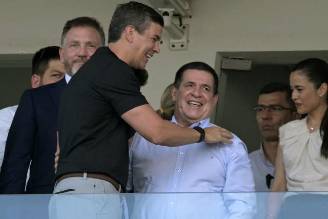 (FILES) Paraguay's President Santiago Pena (3rd L), Paraguayan former President (2013-2018) Horacio Cartes (C), and Conmebol's president Paraguayan Alejandro Dominguez (2nd L) attend the Copa Sudamericana final football match between Argentina's Racing and Brazil's Cruzeiro at La Nueva Olla Stadium in Asuncion on November 23, 2024. On October 6, 2025, the U.S. Treasury lifted sanctions imposed in 2023 on former Paraguayan President Horacio Cartes, who was accused at the time of “rampant corruption,” a decision confirmed by the leader of the ruling Colorado Party himself. (Photo by JUAN MABROMATA / AFP)
