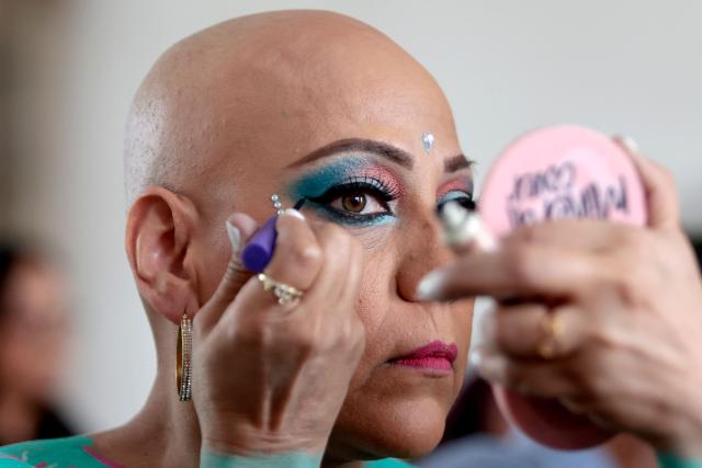A breast cancer survivor applies makeup during the "A Brushstroke for Life" project in Guadalajara, Jalisco state, Mexico, on October 6, 2025. "A Brushstroke for Life" is an altruistic project involving more than 100 women survivors aiming to raise awareness about breast cancer worldwide during October, Breast Cancer Awareness Month for both women and men. (Photo by Ulises Ruiz / AFP)